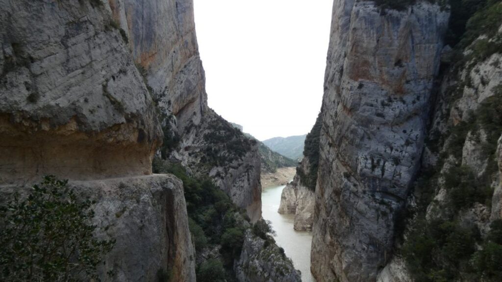 Pasarelas de madera ancladas en la pared vertical del Congost de Mont-rebei con senderistas progresando