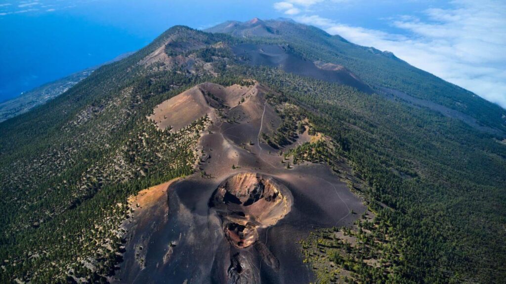Senderistas caminando por la cresta de un cráter volcánico en la isla de La Palma.